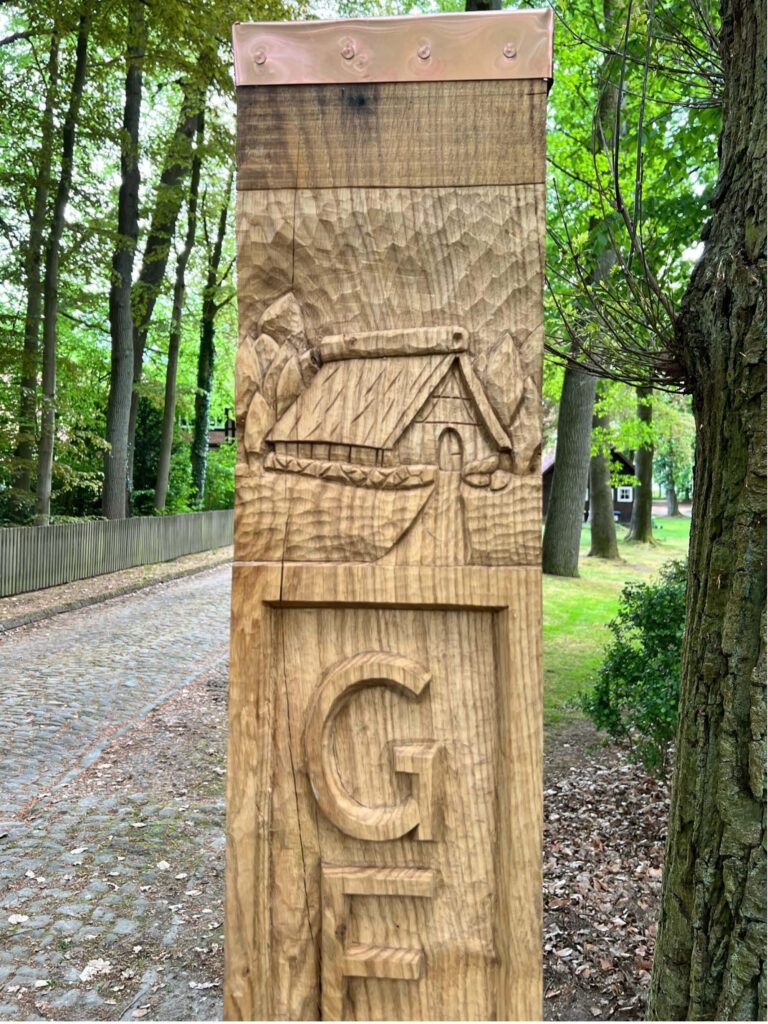 Wegweiser in einem Dorf handgeschnitzt und entworfen